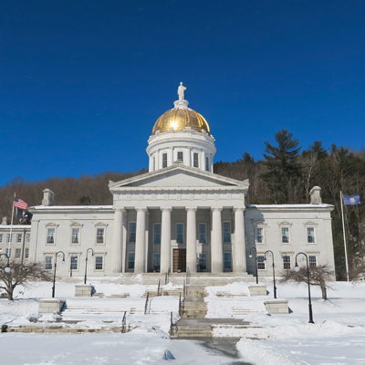 Vermont state house in Winter, with snow on the ground.